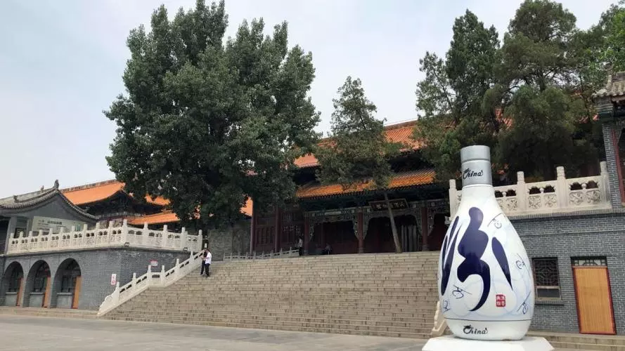 Building with large white bottle of alcohol at the foot of its steps