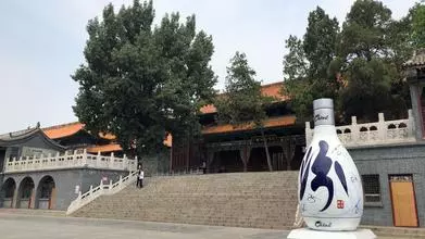 Building with large white bottle of alcohol at the foot of its steps